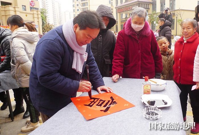 小品演员杨建伟在为群众书写“富”字。