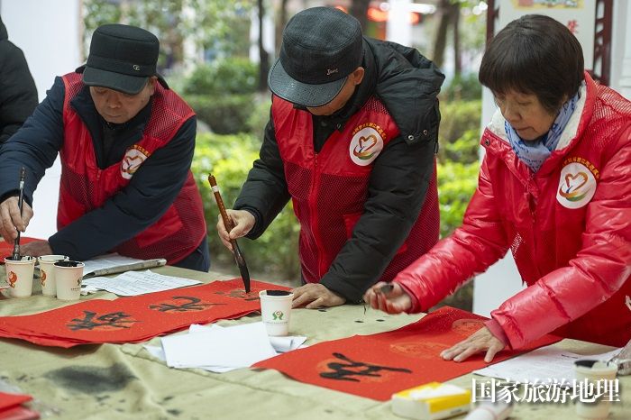 8、2024年1月27日，在广西梧州市万秀区蓝天港湾小区迎春文化活动现场，志愿者为居民写春联。（何华文）