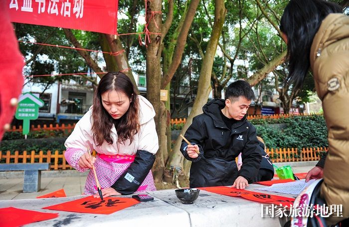 2024年1月22日，在贵州省从江县城区街道，书法爱好者为市民书写春联。 (2)