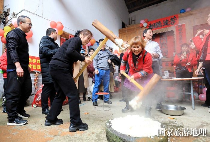 图2：2月13日，广西柳州市融安县雅瑶乡大琴村坡伟屯，村民在打糍粑，庆祝新春佳节。（谭凯兴 摄）