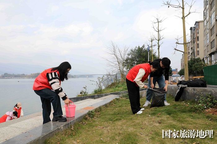 图1：2月19日，在珠江上游融江广西柳州市融安县城段河堤，青年志愿者在清理河堤垃圾。（谭凯兴 摄）