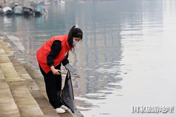 图10：2月19日，在珠江上游融江广西柳州市融安县城段河堤，青年志愿者在清理河堤垃圾。（谭凯兴 摄）