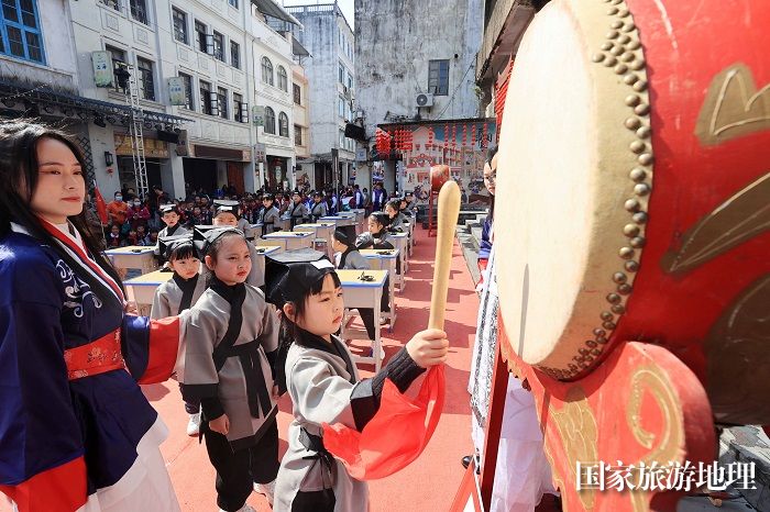 图7：3月11日，在广西柳州市融安县长安镇骑楼街，学生们在“开笔礼”仪式上参加“击鼓明智”。（谭凯兴 摄）