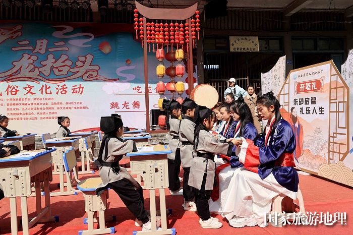 图11：3月11日，在广西柳州市融安县长安镇骑楼街，学生们在“开笔礼”仪式上向老师敬茶。（谭凯兴 摄）