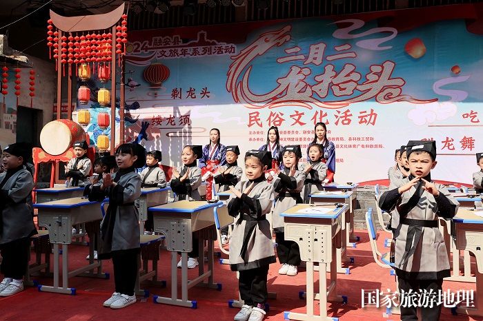 图13：3月11日，在广西柳州市融安县长安镇骑楼街，学生们在“开笔礼”仪式上向家长行礼。（谭凯兴 摄）