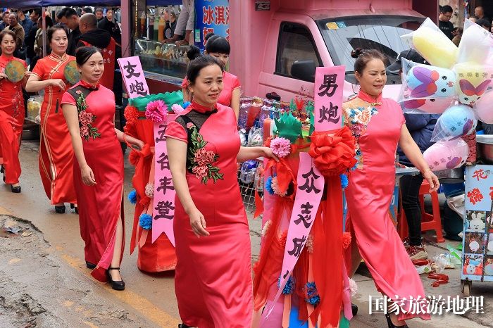 图1：3月13日，在广西柳州市融安县大将镇二月初四传统会期上，工作人员抬着男女花炮游街展示。（谭凯兴 摄）