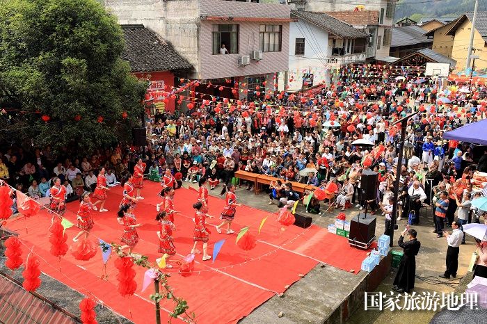 图9：3月25日，在广西柳州市融安县大将镇龙妙村，人们在二月十六会期上观看文艺演出。（谭凯兴 摄）