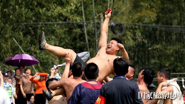 图18：3月25日，在广西柳州市融安县大将镇龙妙村，民众在庆祝抢花炮比赛中夺奖。（覃庆和 摄）