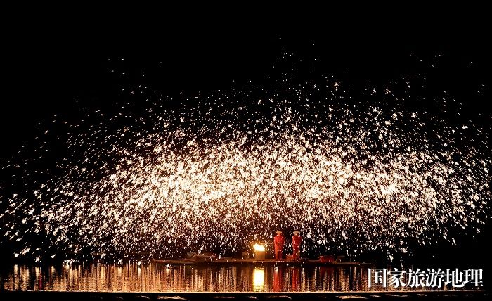 图2：4月8日晚，民间艺人在珠江上游浪溪江广西柳州市融安县雅瑶乡西古坡屯段江面上表演打铁花。（谭凯兴 摄）