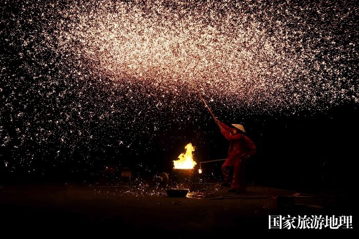 图12：4月23日晚，在广西柳州市融安县雅瑶乡，民间艺人在表演非遗打铁花。（谭凯兴 摄）