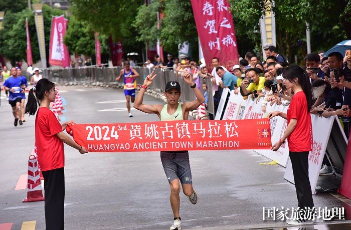 以2小时32分41秒成绩夺得男子全马冠军的邱远青冲线时刻。廖祖平摄