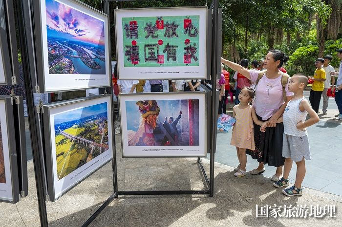 2、2024年7月20日，居民在广西梧州市万秀区蓝天社区蓝天港湾小区观看摄影展。（何华文）